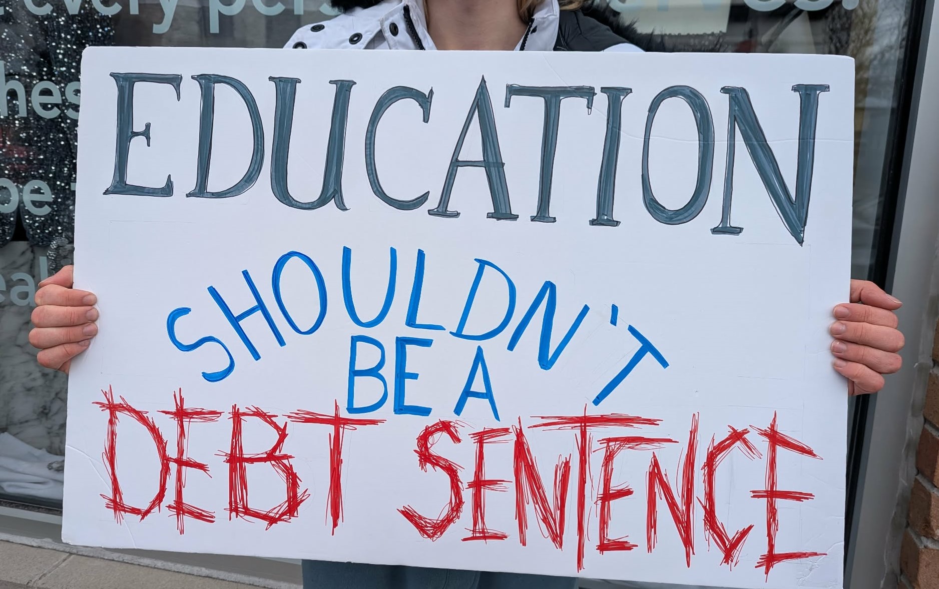 Protest photo saying "Education shouldn't be a debt sentence"
